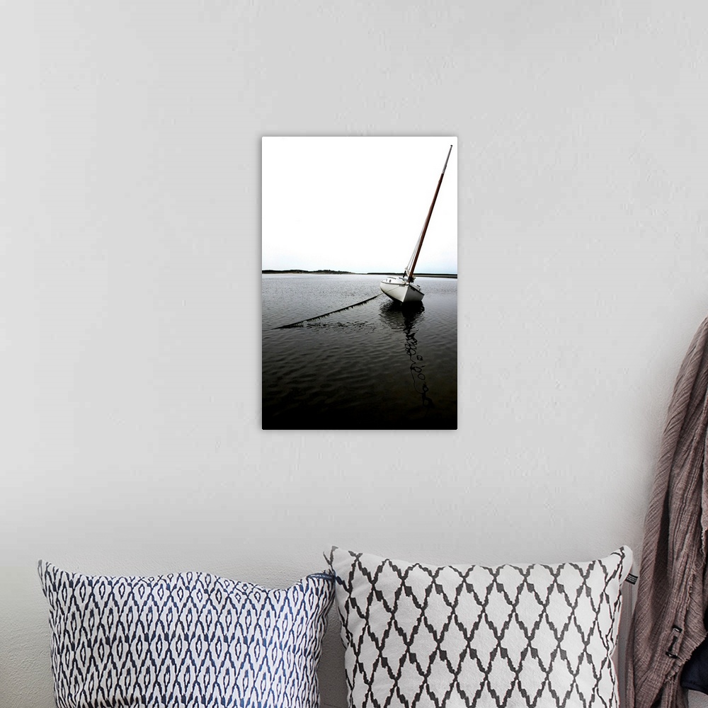 A bohemian room featuring Photograph of an anchored sailboat in calm waters.