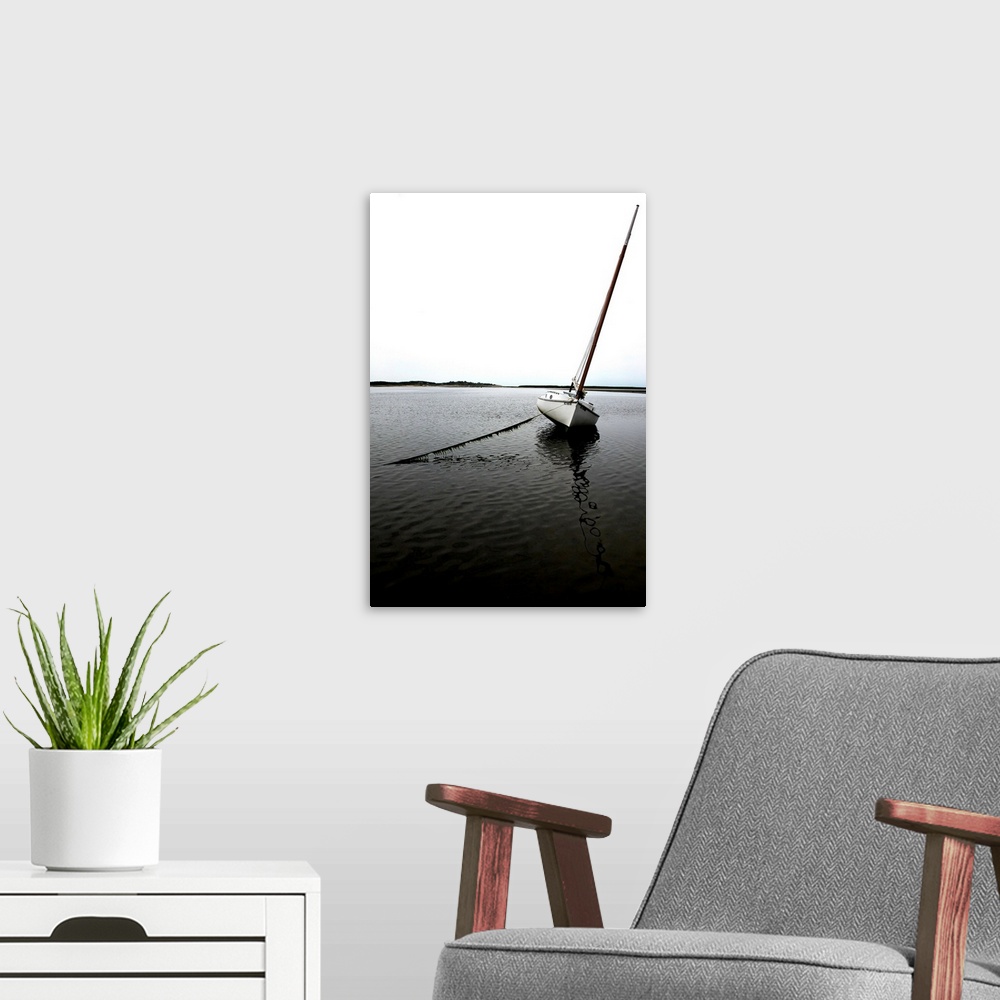 A modern room featuring Photograph of an anchored sailboat in calm waters.