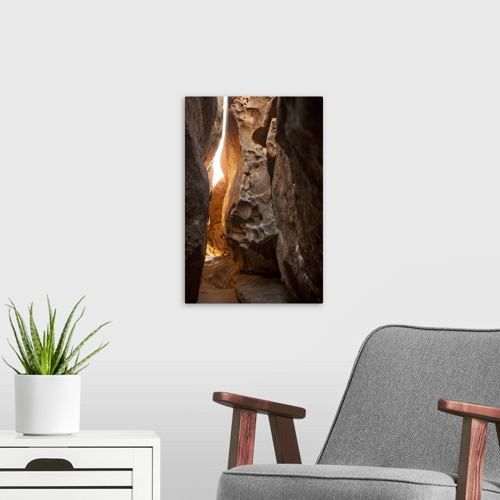 A modern room featuring A photograph of looking through a tight canyon.
