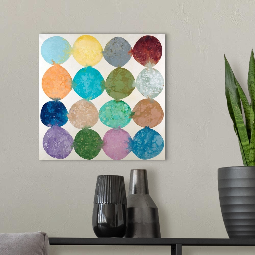 A modern room featuring Abstract artwork with colorful circles placed together in rows with their hues bleeding into the ...