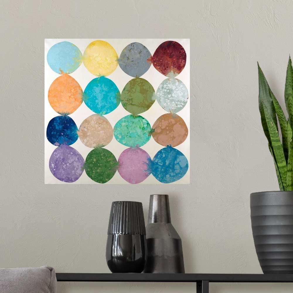 A modern room featuring Abstract artwork with colorful circles placed together in rows with their hues bleeding into the ...