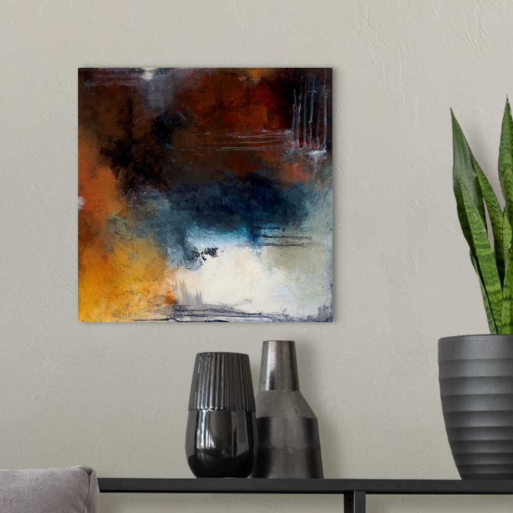 A modern room featuring Square abstract painting with splotches of deep red, orange, and blue hues and a pop of bright wh...