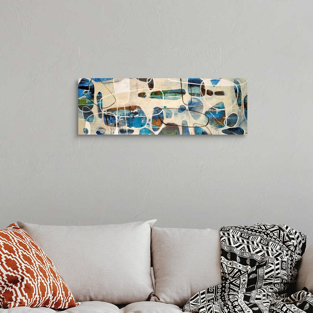 A bohemian room featuring Abstract painting of oval, stone like shapes scattered on a panoramic sized art canvas.