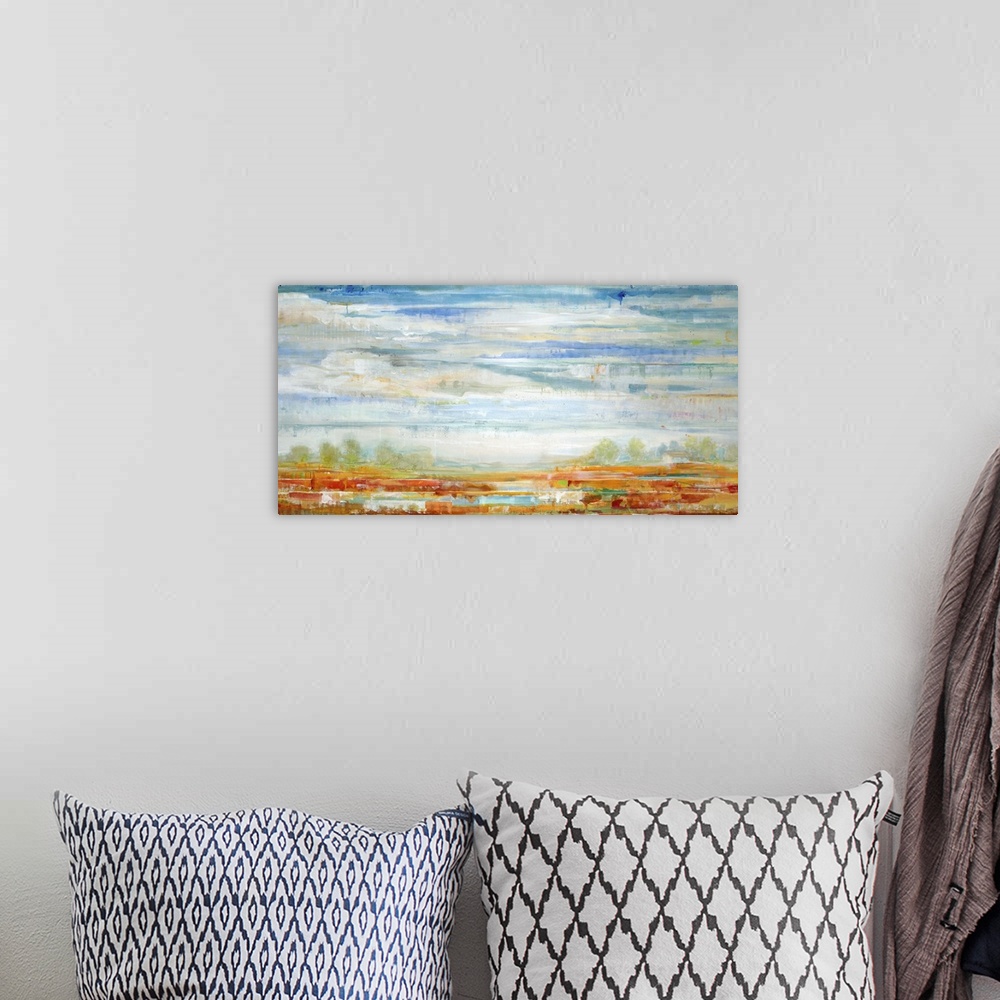 A bohemian room featuring Contemporary landscape painting looking out over red fields under a vibrant blue cloudy sky.