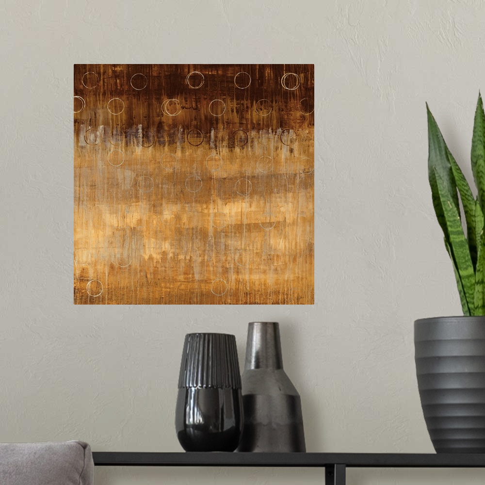 A modern room featuring Abstract painting on a square canvas of circles drawn over top of an earth toned gradient.