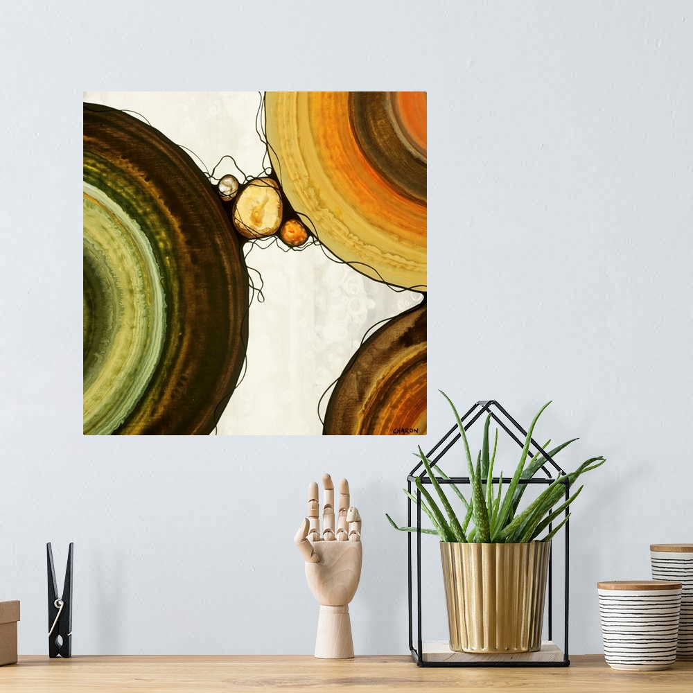 A bohemian room featuring Abstract painting with a geometric circle designs in orange, yellow, green, and brown tones on a ...