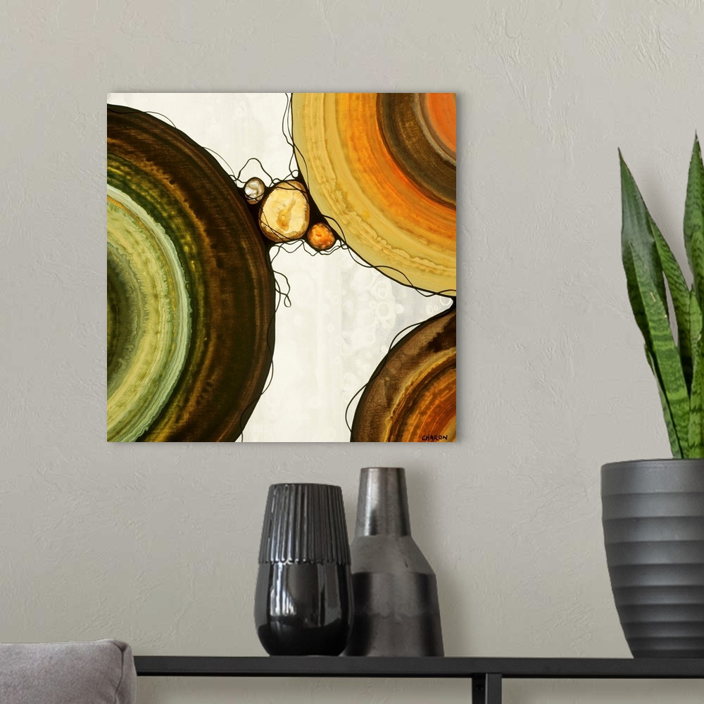 A modern room featuring Abstract painting with a geometric circle designs in orange, yellow, green, and brown tones on a ...