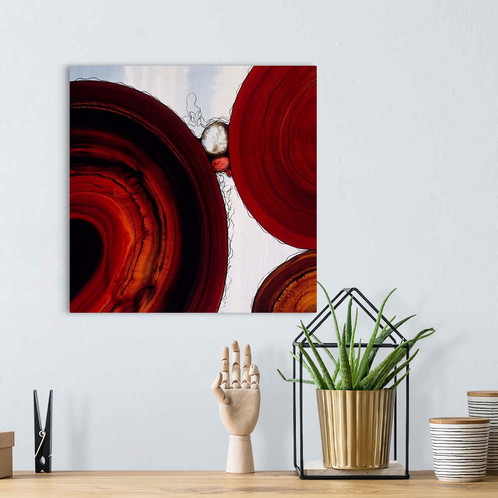 A bohemian room featuring Abstract painting with a geometric circle designs in red and orange tones on a faded blue and whi...