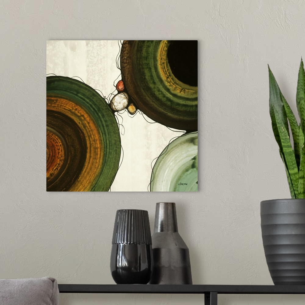 A modern room featuring Abstract painting with a geometric circle designs in orange, yellow, green, and brown tones on a ...
