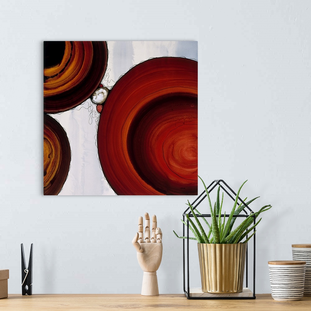 A bohemian room featuring Abstract painting with a geometric circle designs in red and orange tones on a faded blue and whi...