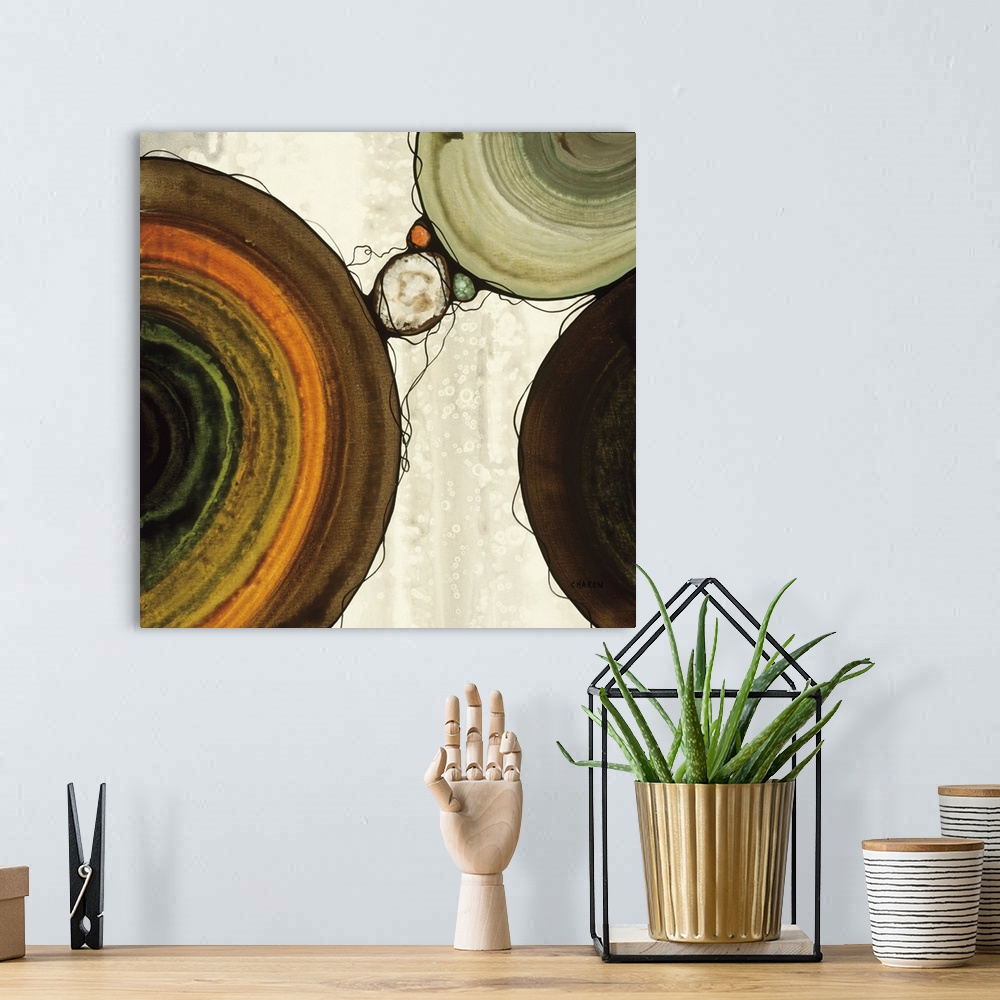 A bohemian room featuring Abstract painting with a geometric circle designs in orange, yellow, green, and brown tones on a ...