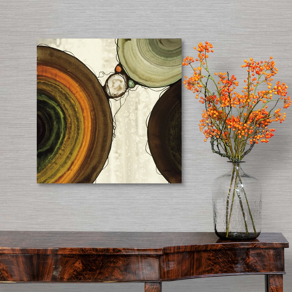 A traditional room featuring Abstract painting with a geometric circle designs in orange, yellow, green, and brown tones on a ...