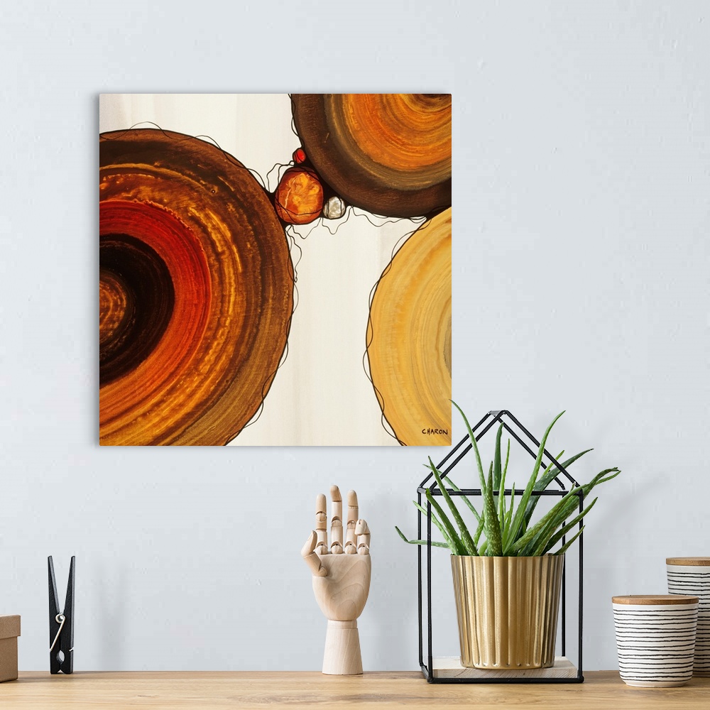 A bohemian room featuring Abstract painting with a geometric circle designs in red, yellow, and orange tones on a faded cre...