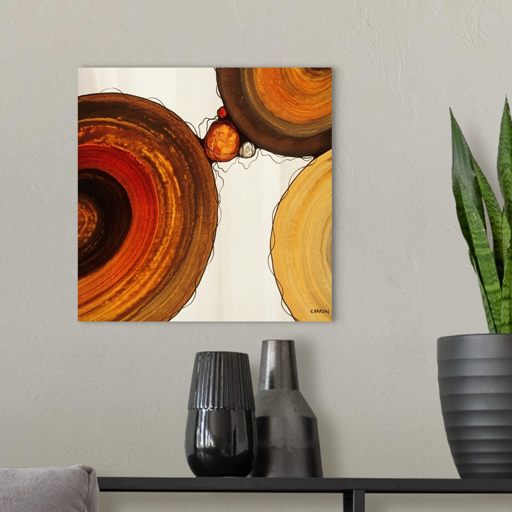 A modern room featuring Abstract painting with a geometric circle designs in red, yellow, and orange tones on a faded cre...