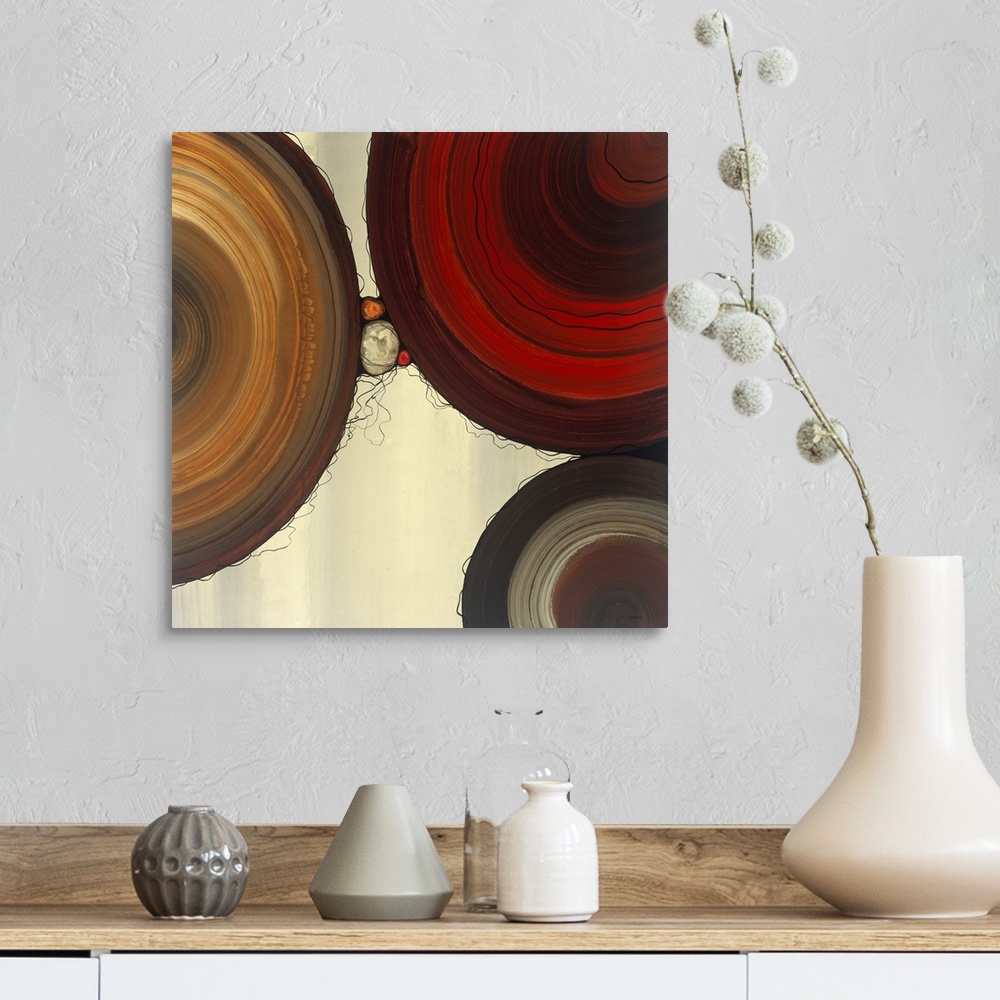 A farmhouse room featuring Abstract painting with a geometric circle designs in red, yellow, and orange tones on a faded cre...
