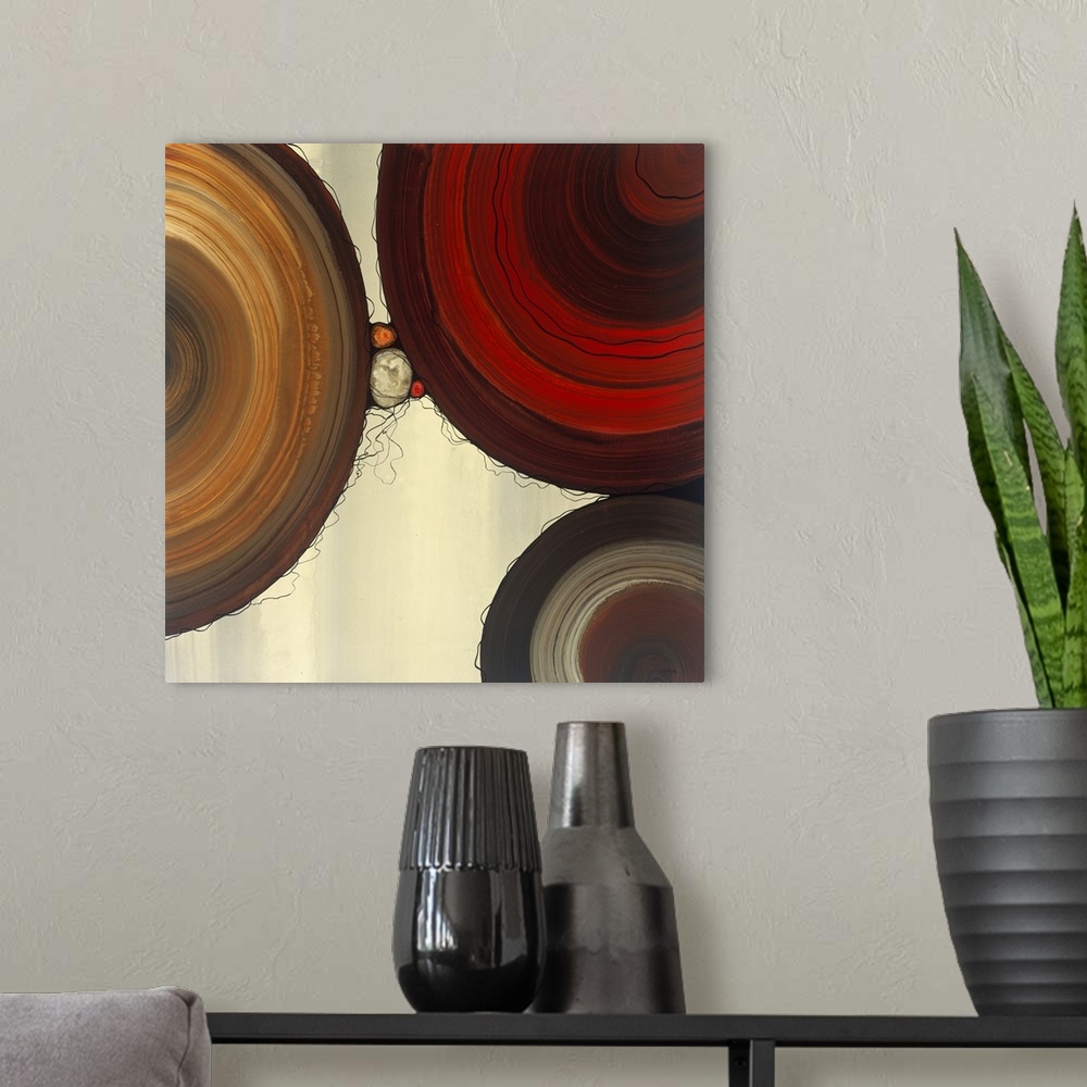 A modern room featuring Abstract painting with a geometric circle designs in red, yellow, and orange tones on a faded cre...
