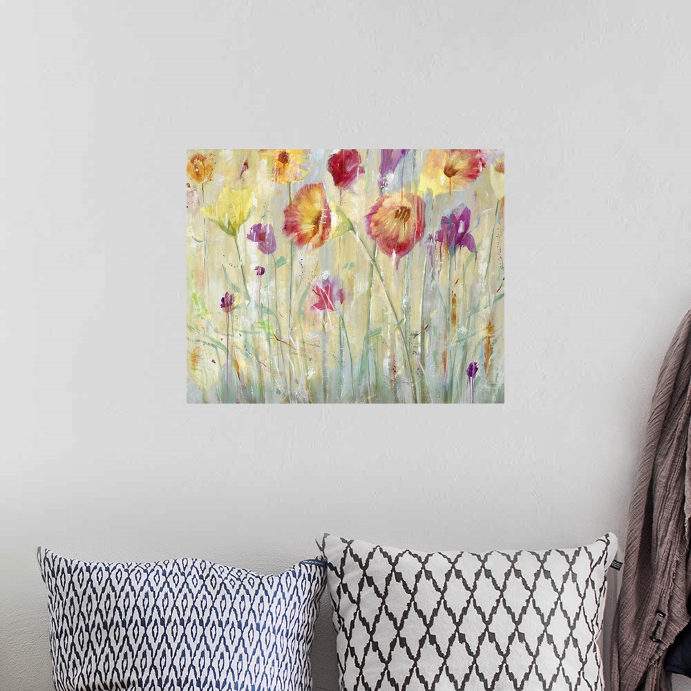 A bohemian room featuring A contemporary painting of vibrant red purple and yellow flowers in a garden.