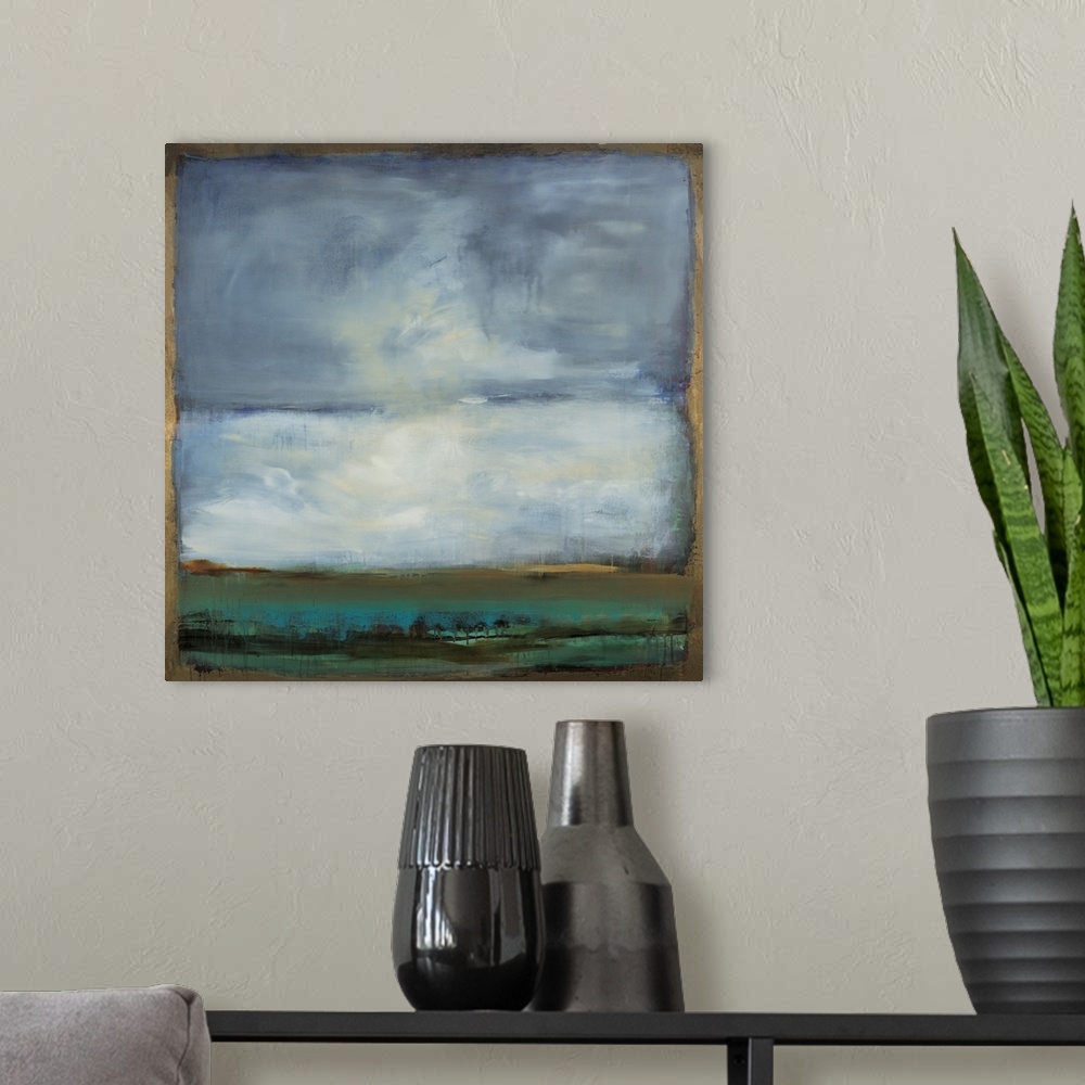 A modern room featuring Square abstract painting of a landscape with blue, green, and black hues and a gold boarder and l...
