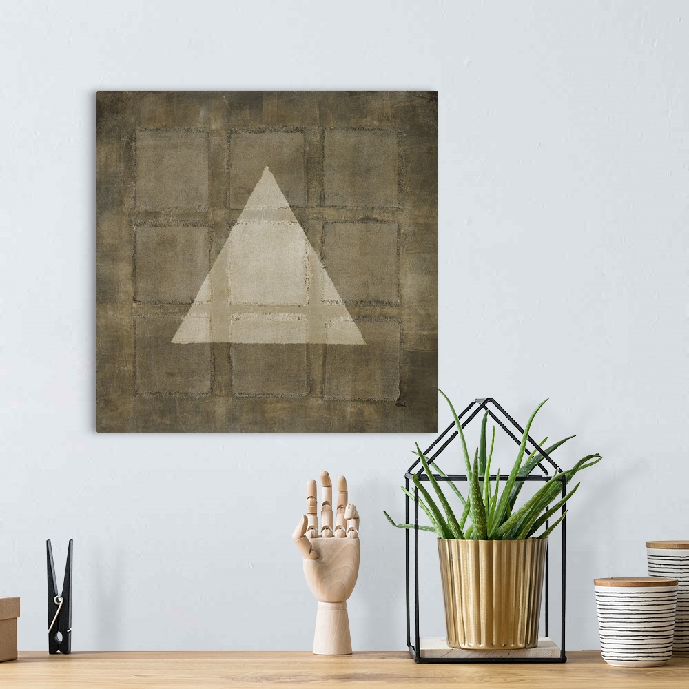 A bohemian room featuring A modern painting of nine squares with a light colored triangle overlapping, all in varies shades...