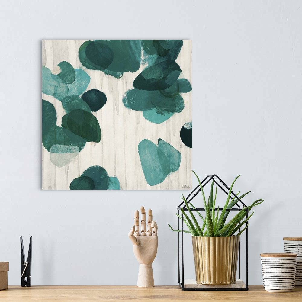 A bohemian room featuring A contemporary abstract painting of teal green flake shapes against a neutral toned background.