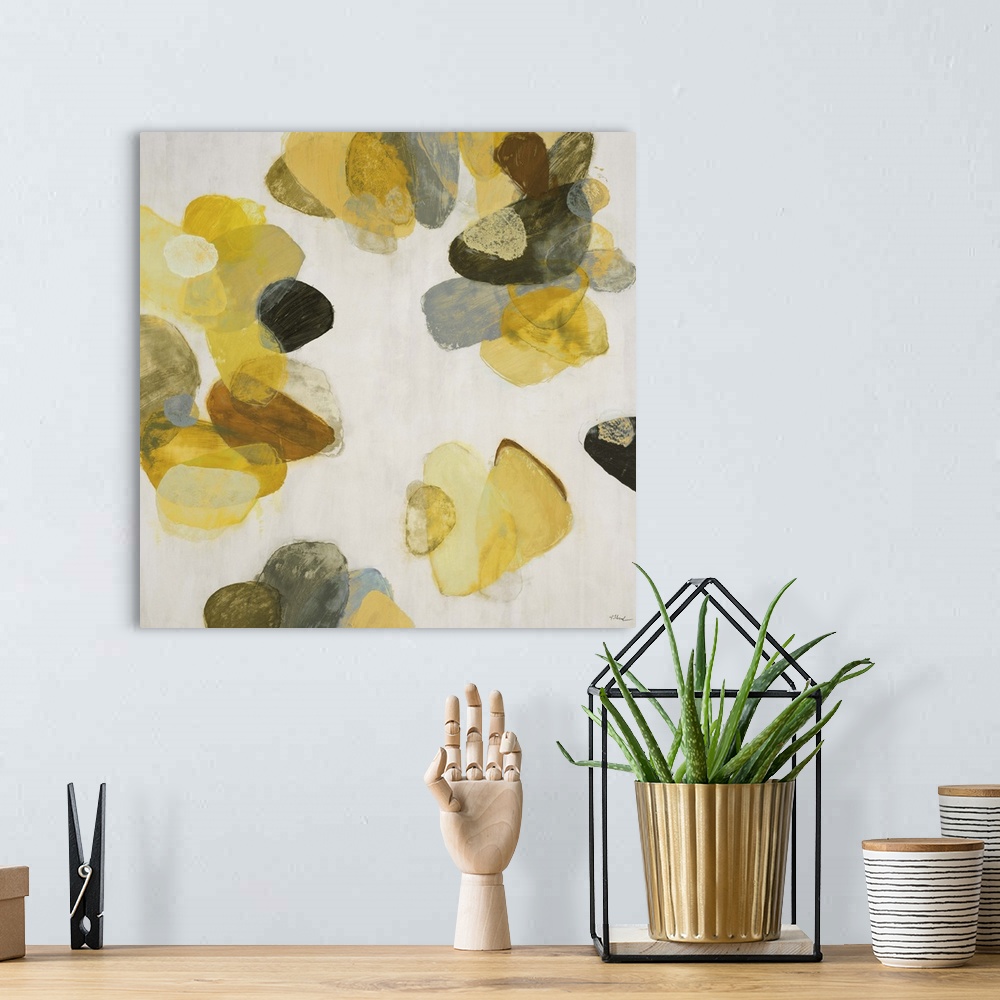A bohemian room featuring A contemporary abstract painting of golden yellow flake shapes against a neutral toned background.