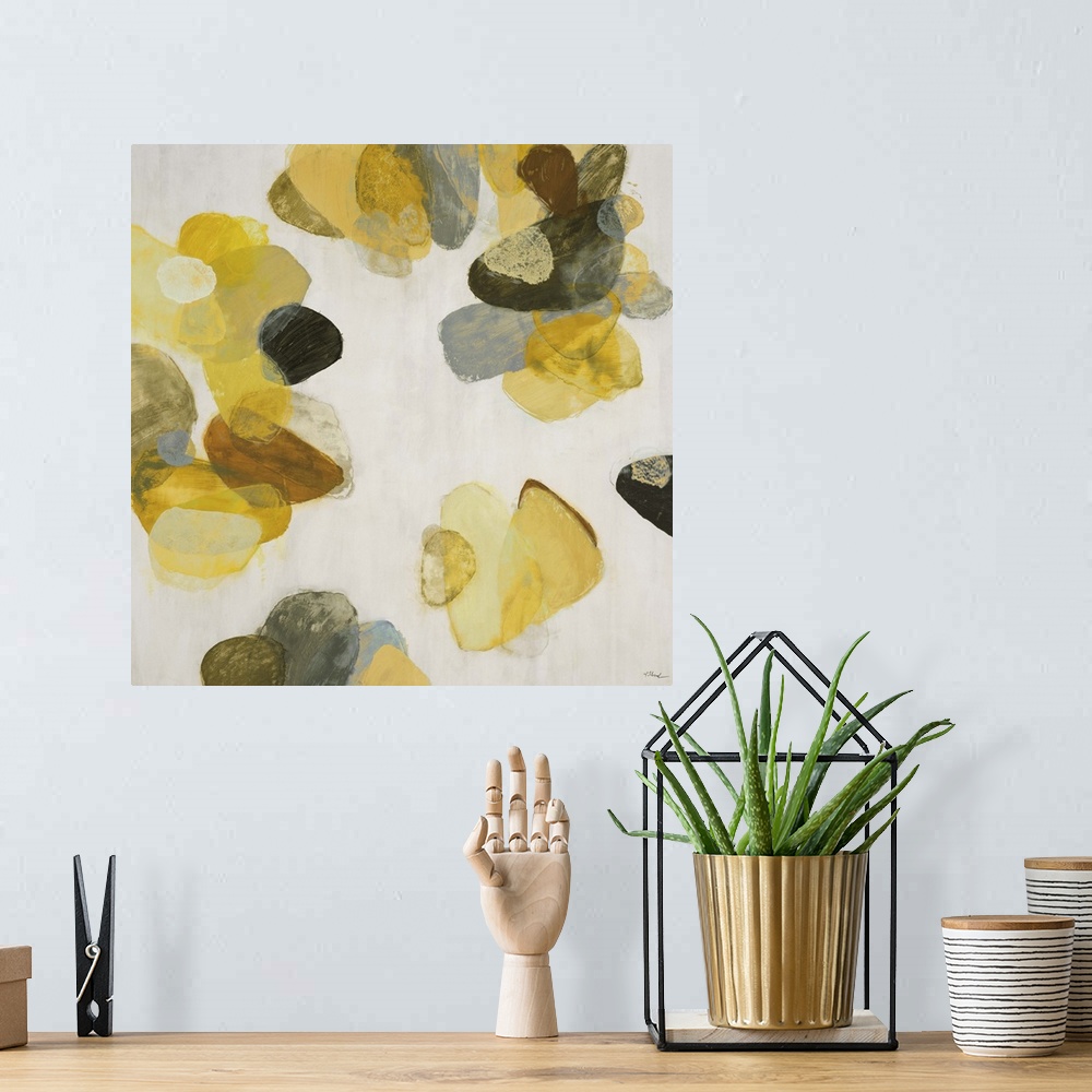 A bohemian room featuring A contemporary abstract painting of golden yellow flake shapes against a neutral toned background.