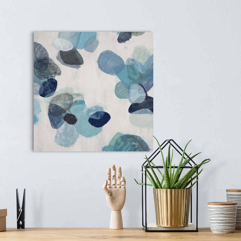 A bohemian room featuring A contemporary abstract painting of blue flake shapes against a neutral toned background.