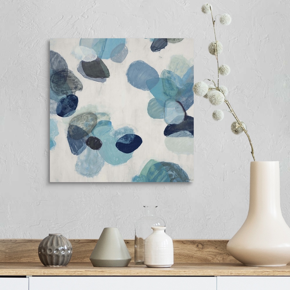 A farmhouse room featuring A contemporary abstract painting of blue flake shapes against a neutral toned background.