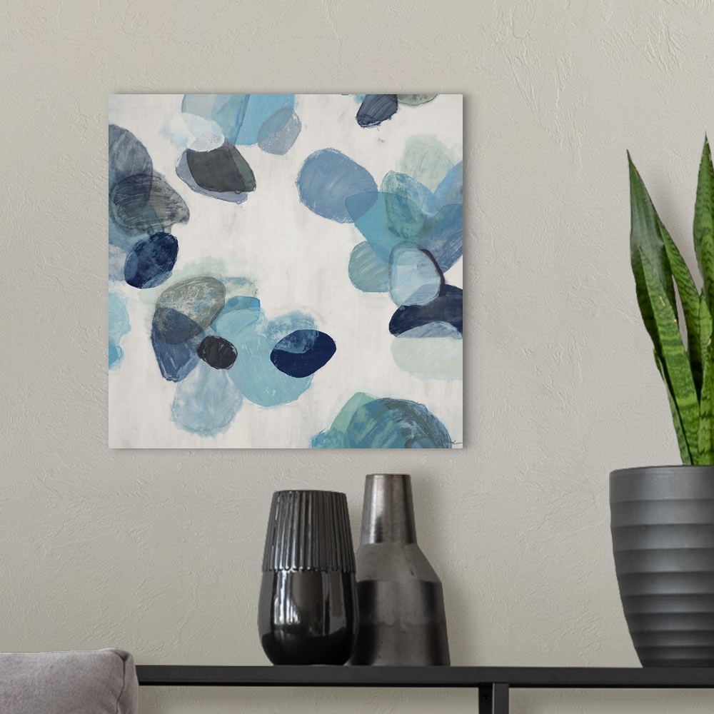 A modern room featuring A contemporary abstract painting of blue flake shapes against a neutral toned background.
