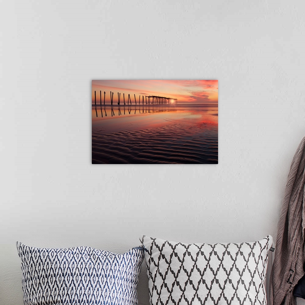 A bohemian room featuring Old wooden pier seen from the beach during a dramatic sunset.