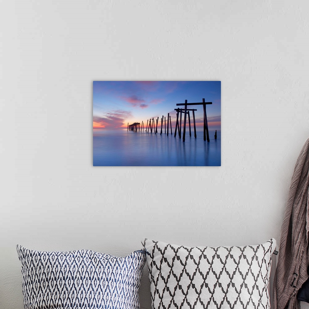 A bohemian room featuring Old wooden pilings from a long-gone pier in the sea off of Ocean City, New Jersey, at dawn.