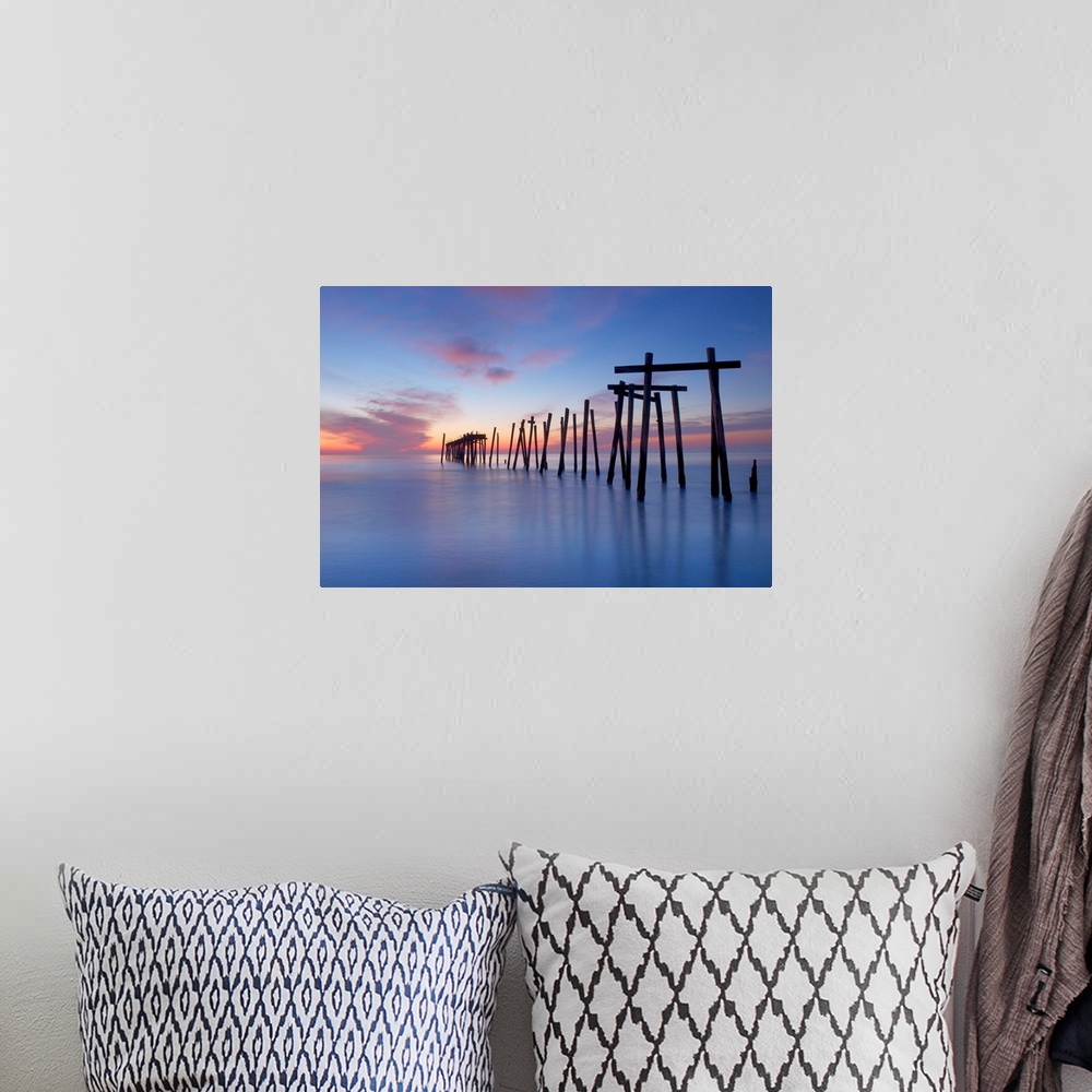 A bohemian room featuring Old wooden pilings from a long-gone pier in the sea off of Ocean City, New Jersey, at dawn.