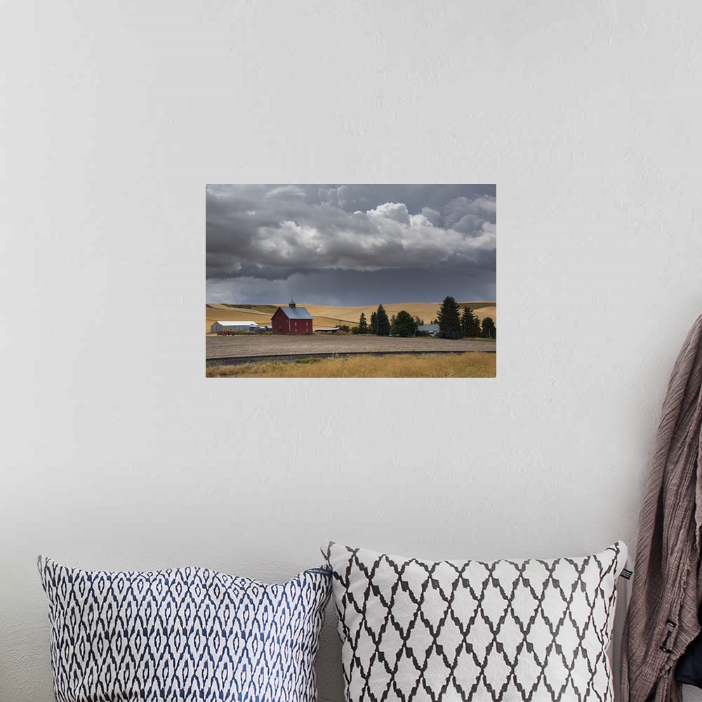 A bohemian room featuring Dark storm clouds over a red barn in Palouse, Washington.
