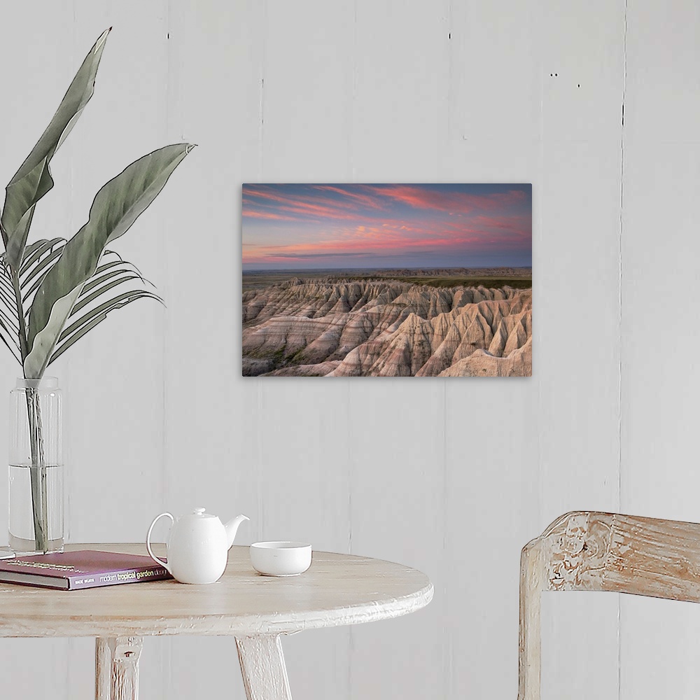 A farmhouse room featuring Pink clouds at dawn over the pointed rocky landscape of the South Dakota badlands.