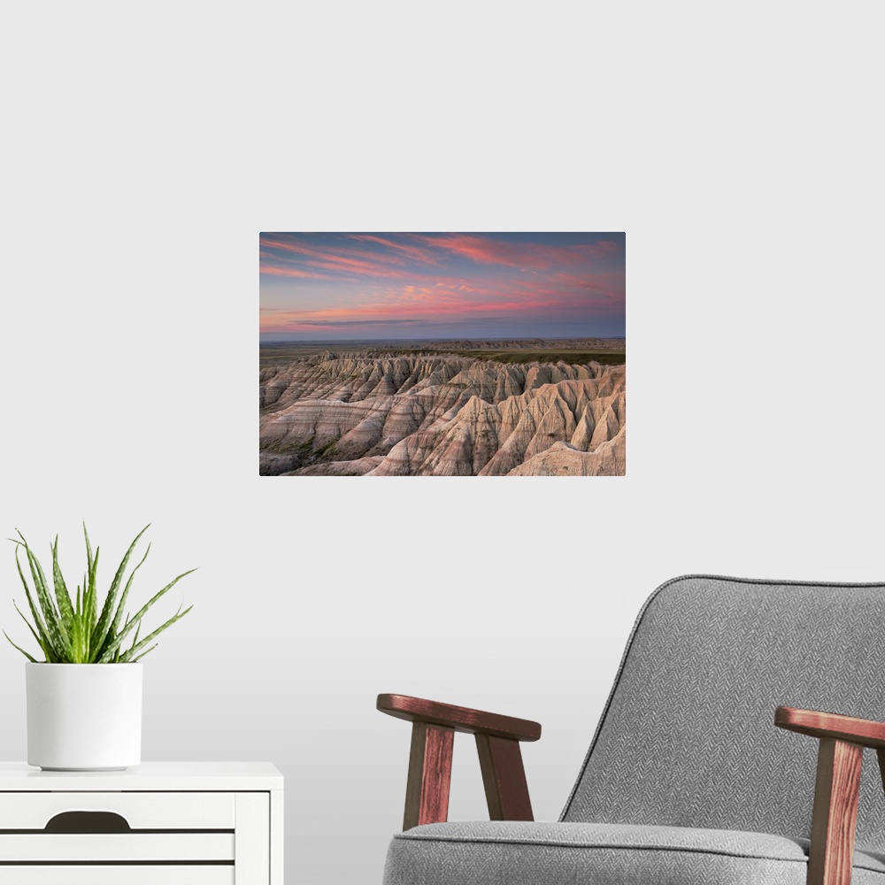 A modern room featuring Pink clouds at dawn over the pointed rocky landscape of the South Dakota badlands.
