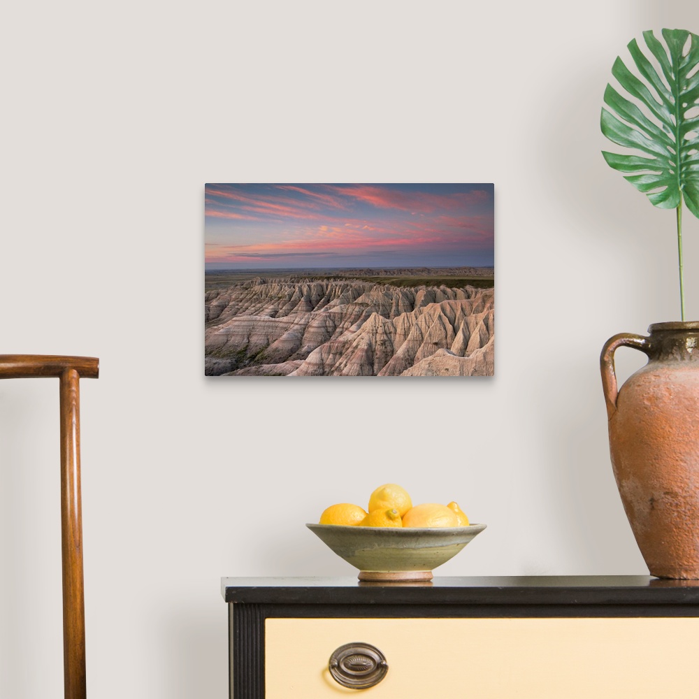 A traditional room featuring Pink clouds at dawn over the pointed rocky landscape of the South Dakota badlands.