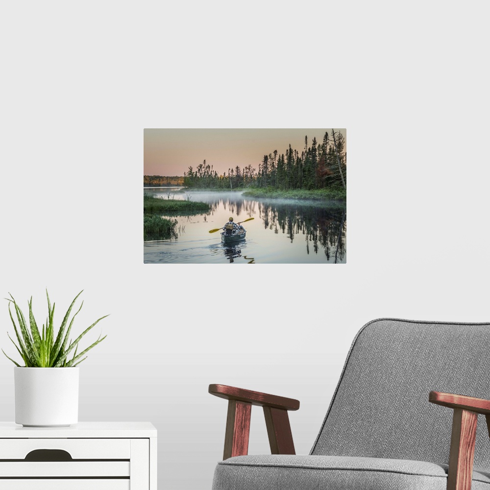 A modern room featuring A canoeist paddling in quiet waters in the morning on Madeline Island, Wisconsin.