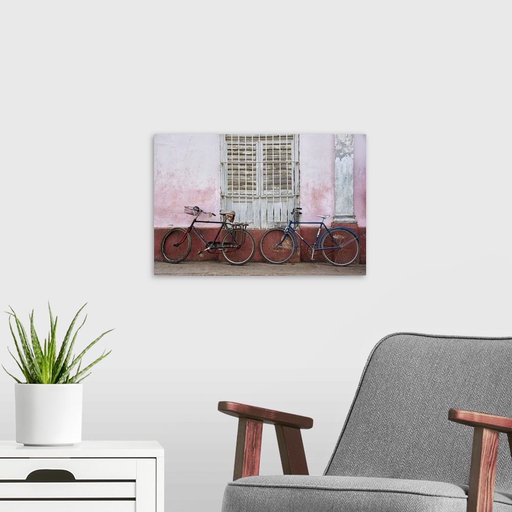 A modern room featuring Two bicycles leaning against a weathered wall in Havana, Cuba.