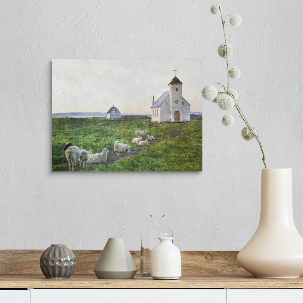 A farmhouse room featuring A small flock of sheep in the field near a white church in Iceland.