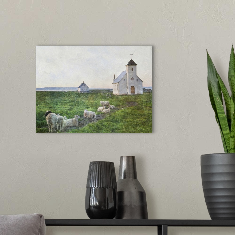 A modern room featuring A small flock of sheep in the field near a white church in Iceland.