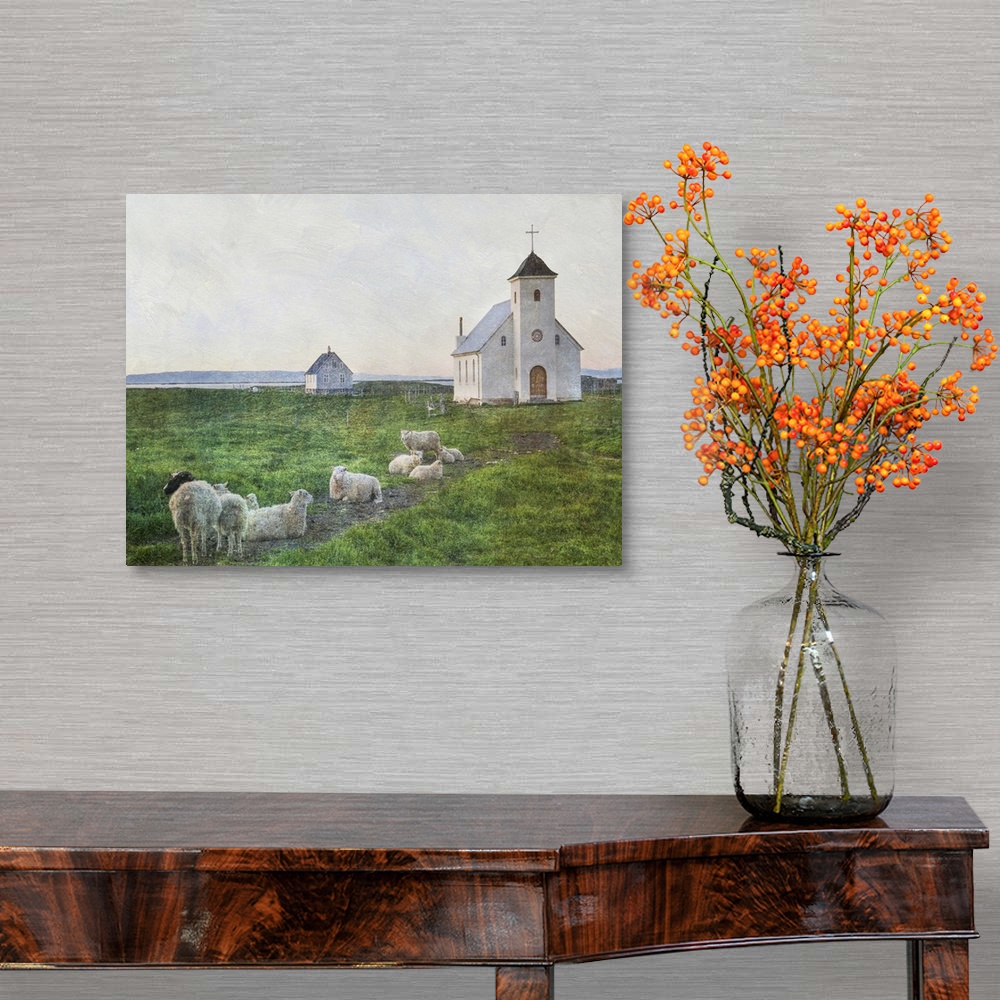A traditional room featuring A small flock of sheep in the field near a white church in Iceland.