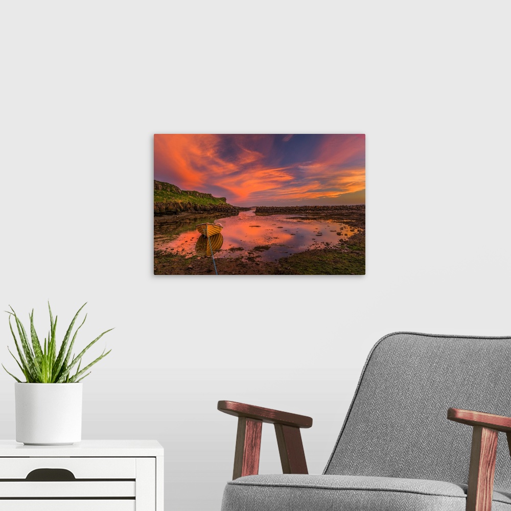 A modern room featuring A canoe moored at low tide under vivid sunset clouds in Iceland.