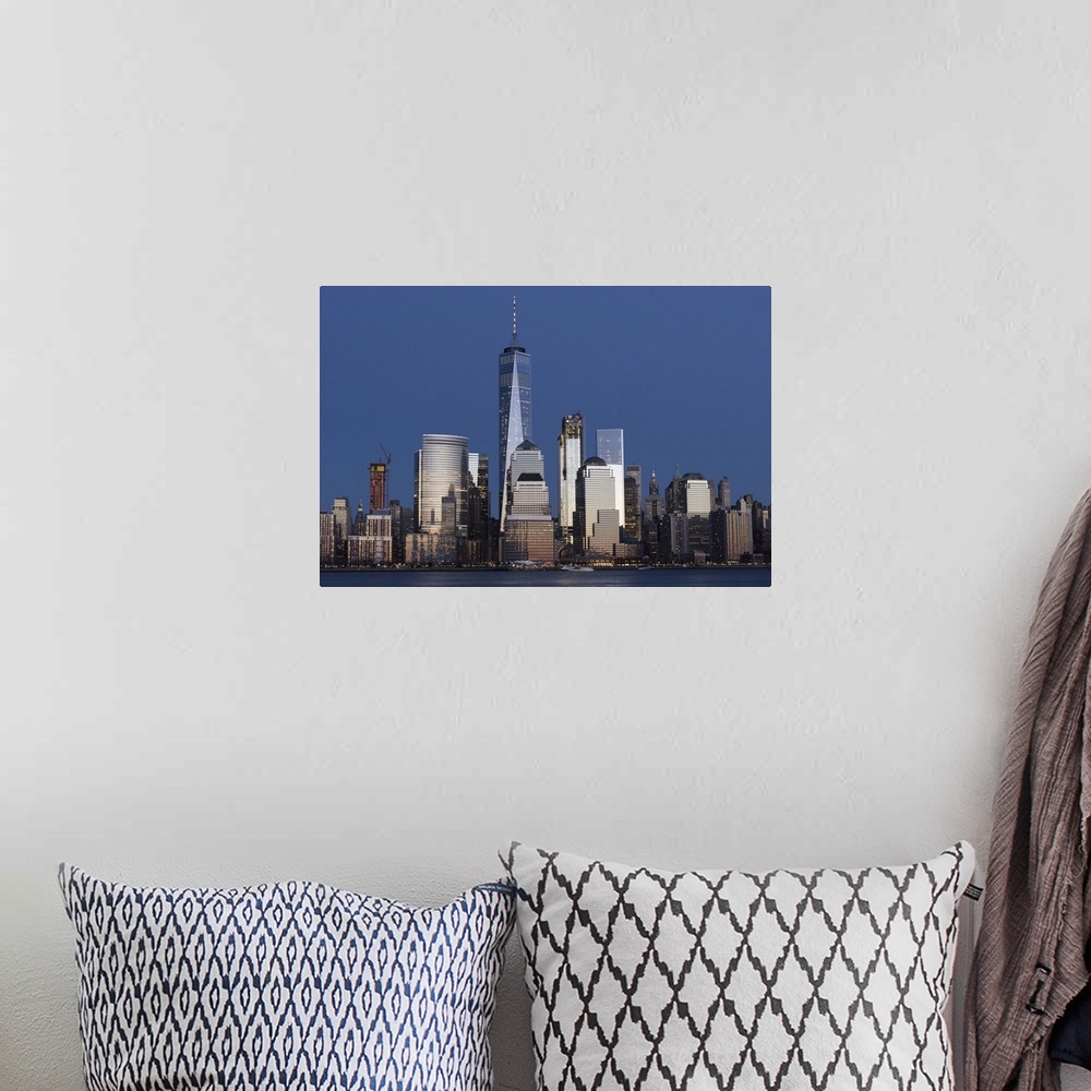 A bohemian room featuring One World Trade and other skyscrapers in the Manhattan skyline at sunset in New York City.