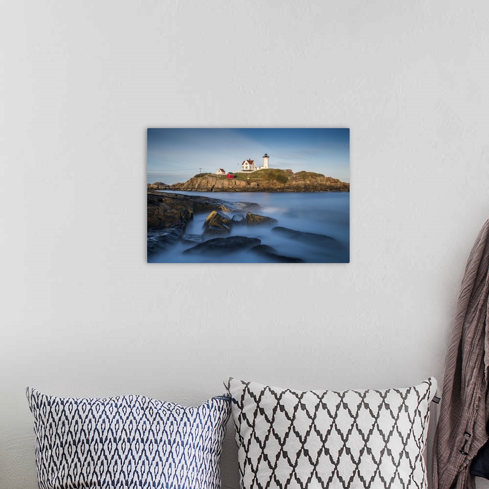 A bohemian room featuring Nubble Lighthouse in Cape Neddick, Maine, on a rocky outcropping in the ocean on the rugged coast.