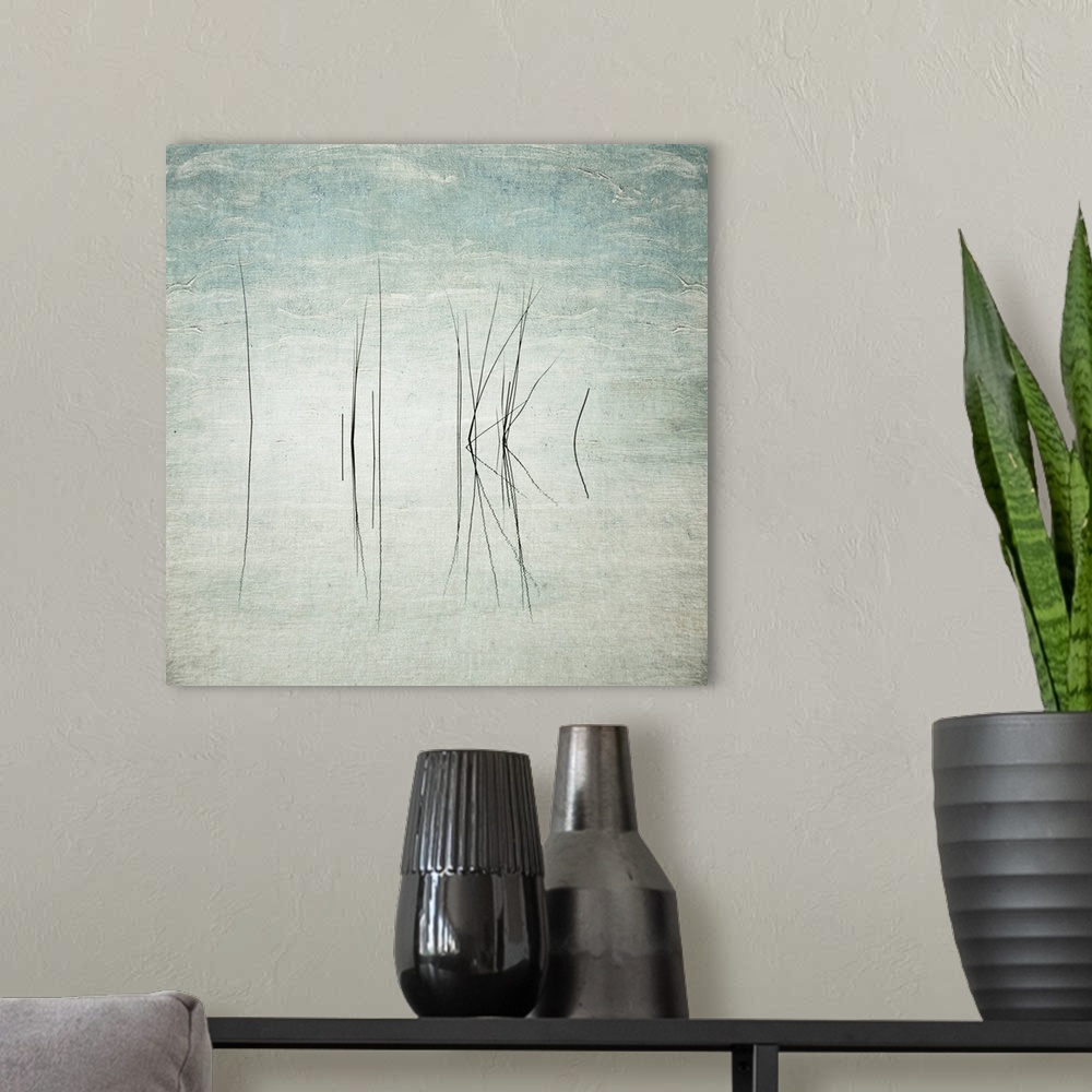 A modern room featuring Abstract photo of thin reeds in the water with mirror images reflected.