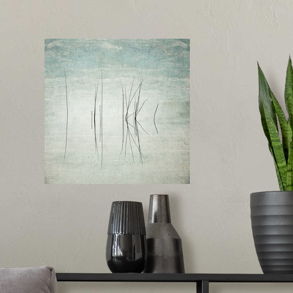 A modern room featuring Abstract photo of thin reeds in the water with mirror images reflected.