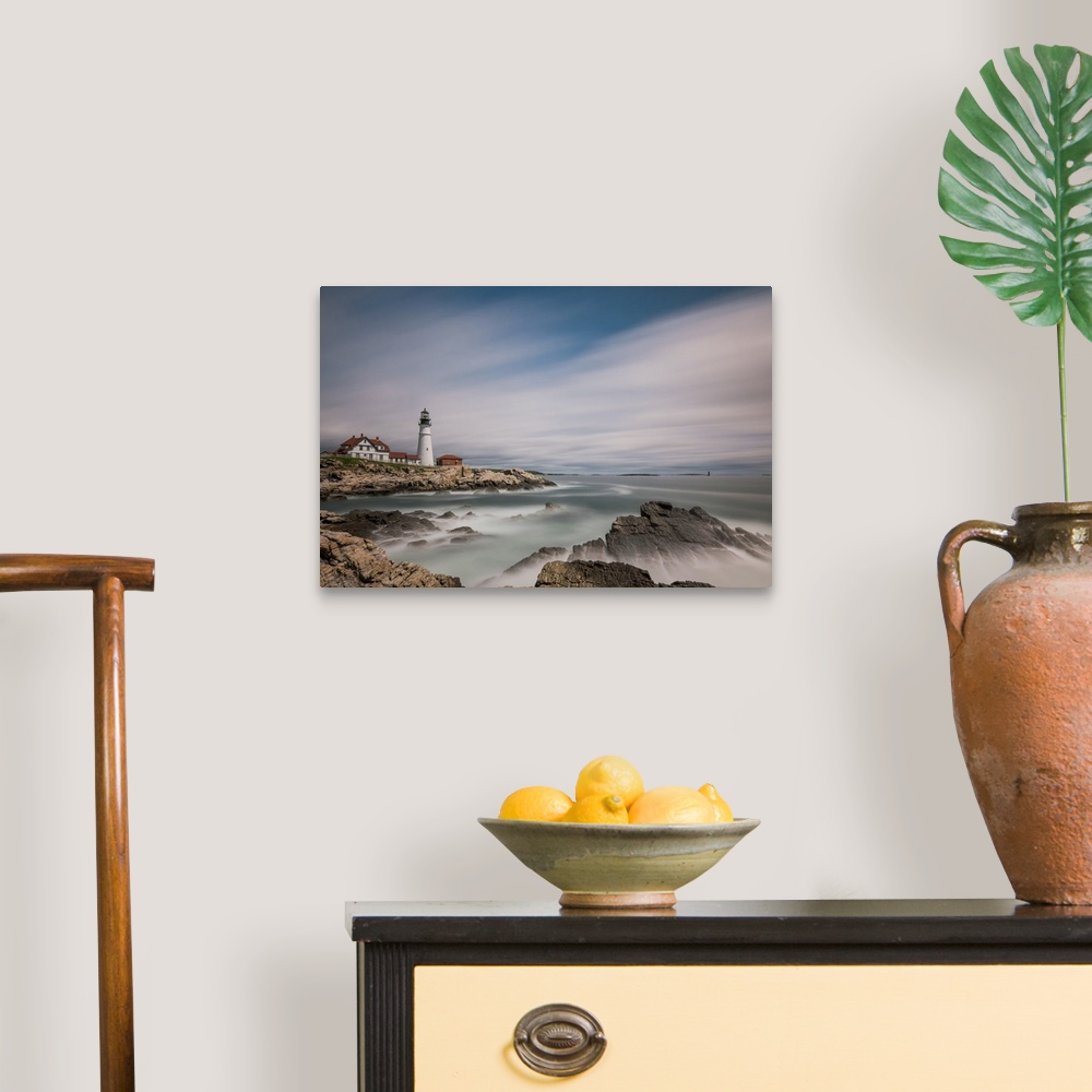A traditional room featuring Lighthouse on the rocky coast of Maine with sweeping clouds above.