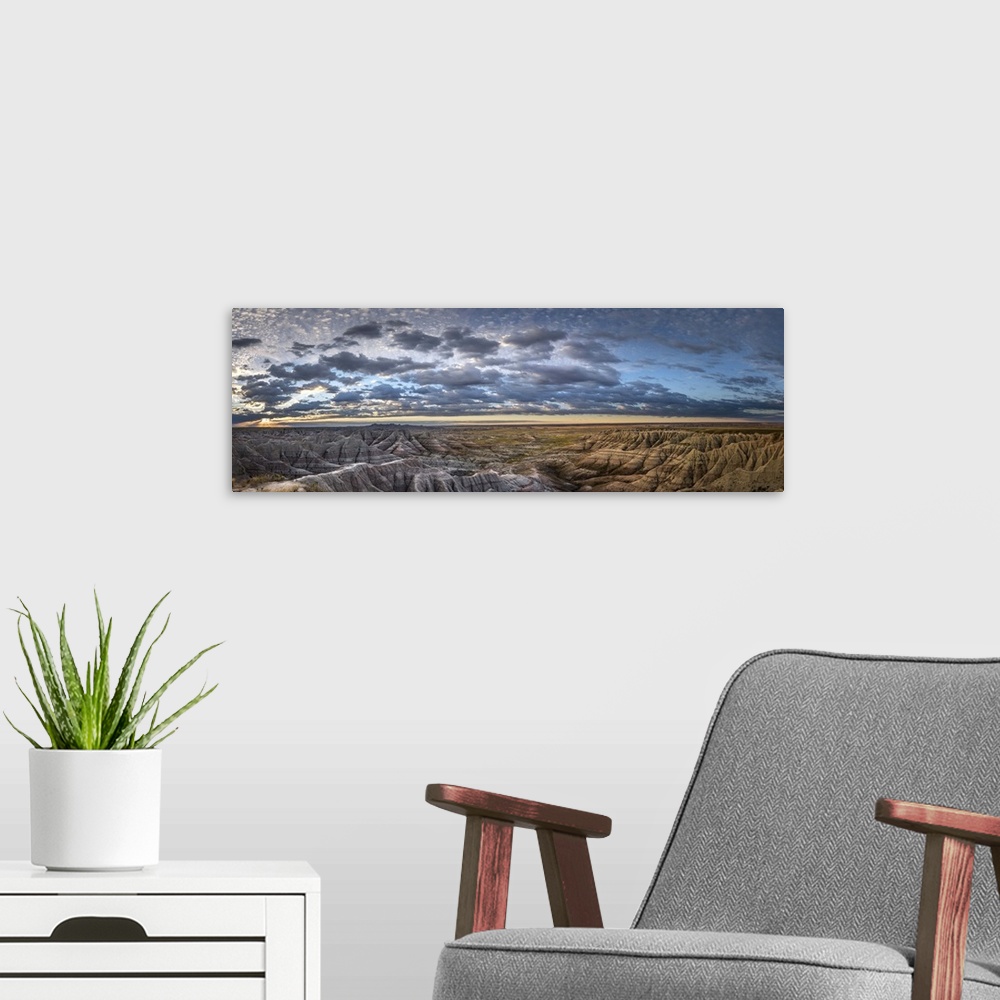 A modern room featuring Panoramic view of stunning clouds at sunset over the hilly terrain of the South Dakota Badlands.