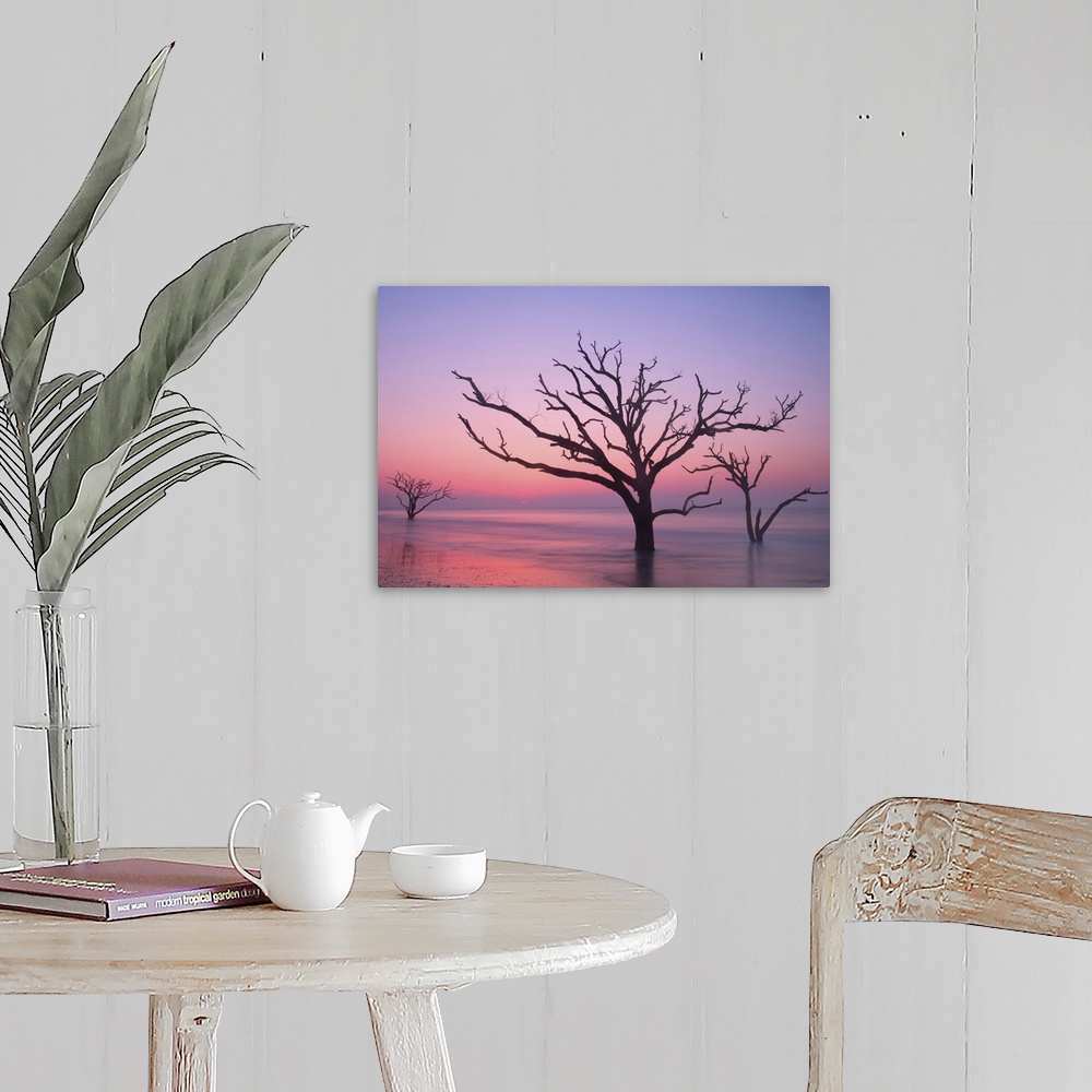 A farmhouse room featuring Silhouettes of trees in the ocean with a pink sky at dawn.
