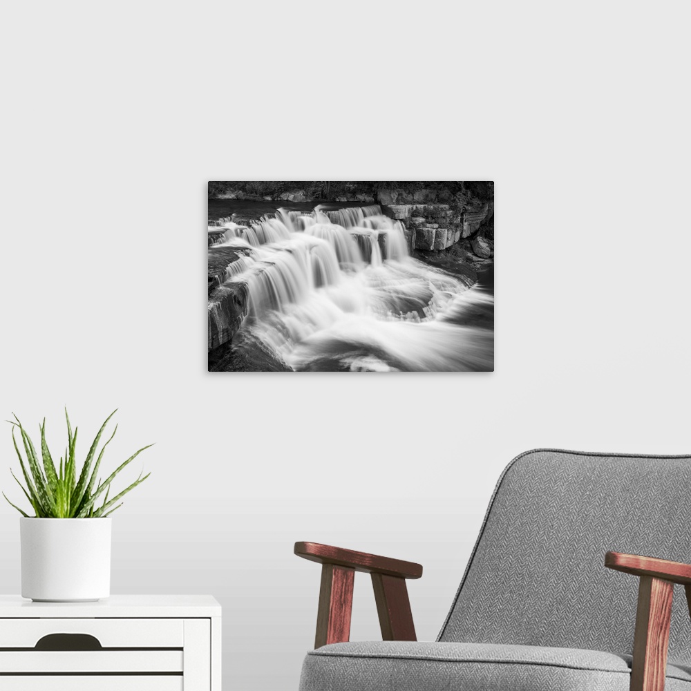 A modern room featuring Black and white image of a rushing waterfall in Ithaca, New York.